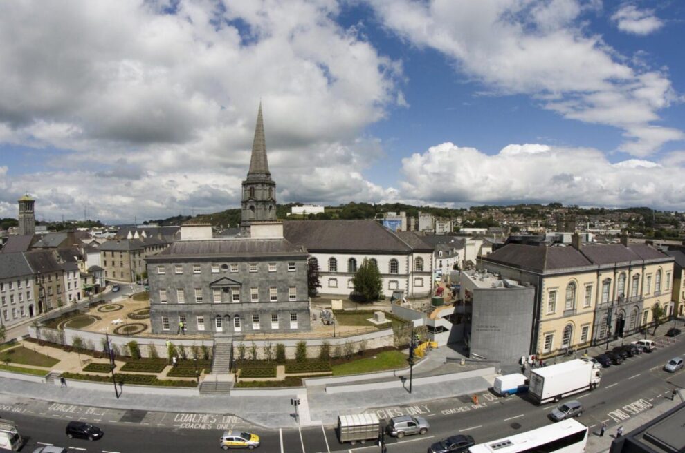 "Bishop's Palace in Viking Triangle, Waterford City with a view of a historic building, greenery, and a path in the foreground."